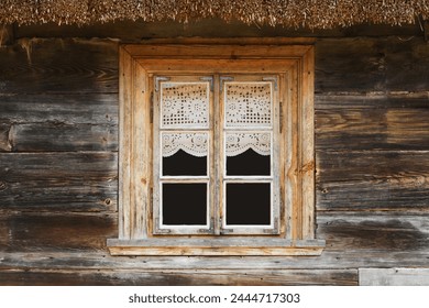 Wooden rustic window in cottage house. Lace curtains glass window home. Rusty architecture. Podlasie region in Poland vintage wall. Wood home wall facade. Thatched roof. - Powered by Shutterstock