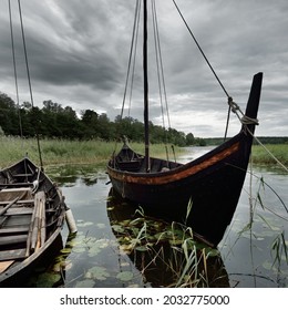 Wooden sailing boats moored to a pier. Birka, Björkö island, lake Mälaren, Sweden. Atmospheric landscape. Travel destinations, landmarks, sightseeing, history, historical reenactment, viking age