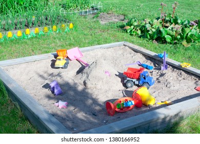 Wooden Sandpit In The Garden With Toys