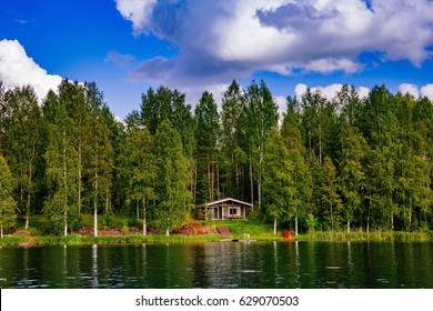 Wooden Sauna Log Cabin At The Lake In Summer In Rural Finland