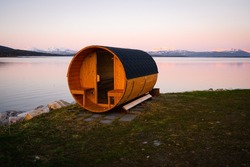 Wooden Sauna On A Beach During Sunset Or Sunrise On A Lake In Troms County In Northern Norway. Sauna Cabin.