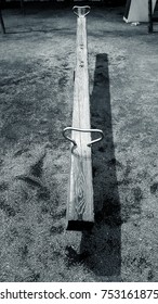 Wooden See Saw With Metal Loop Handles On Sand And Gravel