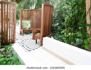 Wooden set with pillows at the hotel, tropical garden of summer day.