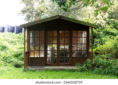 Wooden shed with glass doors and windows - Powered by Shutterstock