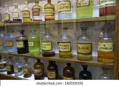 A wooden shelf with antique medicines in glass jars in a circa 1900 mock up pharmacy.