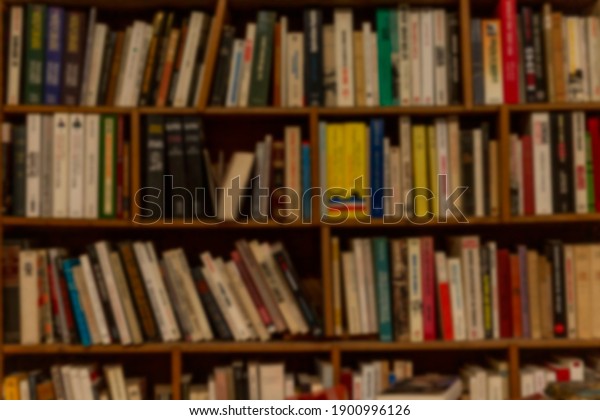 Wooden shelf with books in a row. Education and\
knowledge. Blurred.