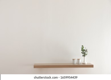 Wooden shelf with decorative elements on light wall - Shutterstock ID 1659954439