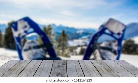 Wooden Shelf Display Table Top Against Blurred Snow Shoes Hiking Shoes And Winter Mountain Panorama On A Sunny Day Blue Sky