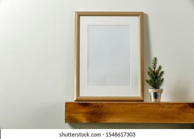 Wooden Shelf Of Free Space For Your Decoration. White Background Of Wall. Christmas Composition With Frame And Empty Space For Your Photo. Winter Time. Copy Space. 