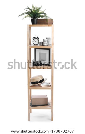 Wooden shelving unit with different items isolated on white