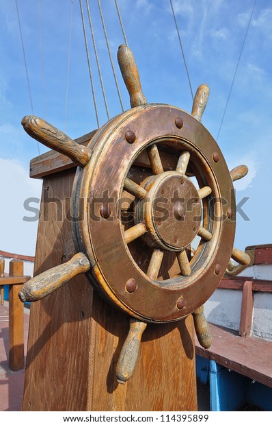 wooden ship wheel on a\
blue background