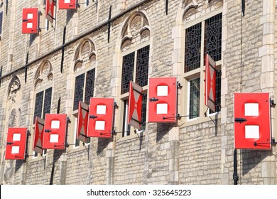 Wooden shutters painted red and white on the facade of Gothic Town Hall building, Gouda, Holland 