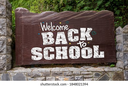 Wooden Sign Outside A School Welcoming Back The Students After Covid-19