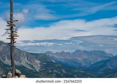 Wooden Sign Post At Summit Of Mountain In The Alps Showing The Direction Of Hiking Trails