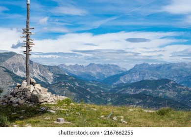 Wooden Sign Post At Summit Of Mountain In The Alps Showing The Direction Of Hiking Trails