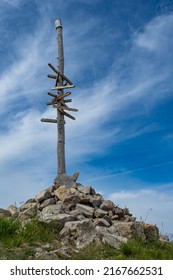 Wooden Sign Post At Summit Of Mountain In The Alps Showing The Direction Of Hiking Trails