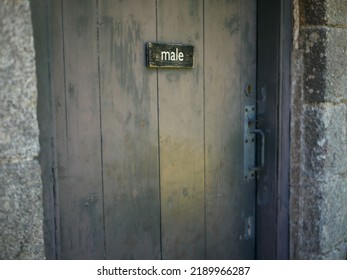 Wooden Sign Saying Male On Men's Bathroom Door At Public Toilets