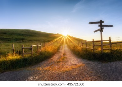 wooden signpost near a path and sunr ays - Shutterstock ID 435721300