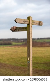 Wooden Signpost Outside On A Public Footpath Through Countryside With A Lost Item Of Clothing