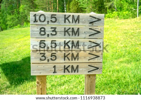 Wooden signs with arrows and distance in kilometres