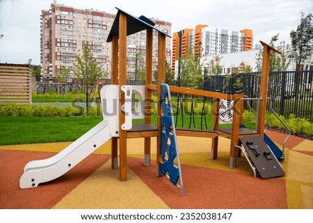 A wooden slide of white blue color with a hinged ladder on the playground in kindergarten on a clear sunny day. Playgrounds, toys, sports.