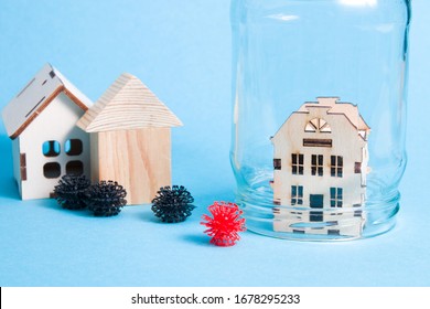 Wooden Small Town House Is Covered With A Glass Jar, Houses On The Background, Blue Background, Quarantine, Health Protection, Virus Models