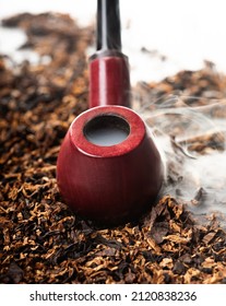 Wooden Smoking Pipe On The Background Of Beautiful Smoke And Tobacco Leaves. Top View. Close-up