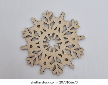 Wooden snowflake on a white background as a premonition of the new year - Shutterstock ID 2073106670