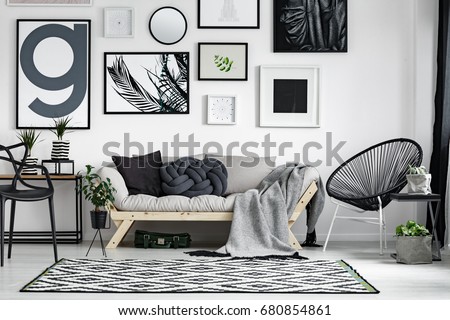 Wooden sofa with dark pillows in scandi style living room