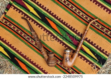Wooden souvenir smoke pipes on the background of a woven hutsul carpet