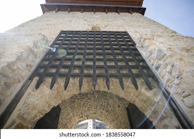 Wooden spikes gate of a sliding door (portcullis) at the entrance of a medieval fortress