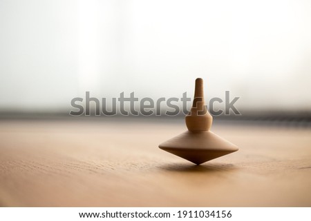 wooden Spinning top in action on wooden flor, rotating totem in motion, wooden, concept