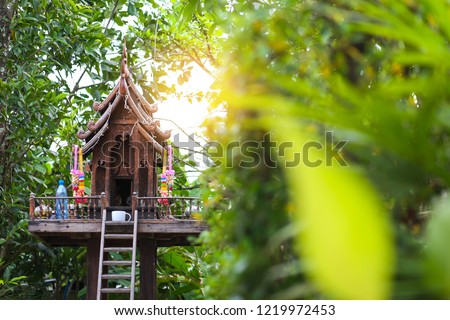 Wooden spirit house under a tree 