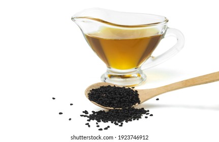 Wooden Spoon With Black Cumin Seeds And Black Seed Oil Isolated On White Background. Selective Focus. 
