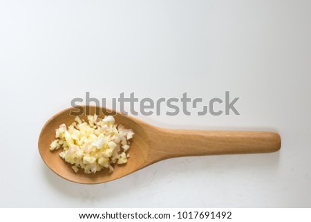 
Wooden spoon of Chopped garlic on desk wood background.
Minced garlic in Wooden ladle on wood background.
top view.