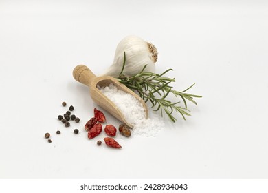 wooden spoon with coarse salt, two sprigs of rosemary, garlic, peppercorns and spicy dried chili peppers - Powered by Shutterstock