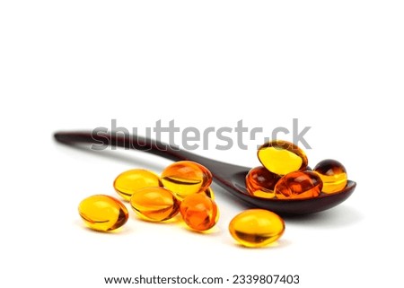 Wooden Spoon with fish oil,Omega-3,lecithin,DHA, Vitamins capsules on white background. healthy supplements,extraction oil capsules