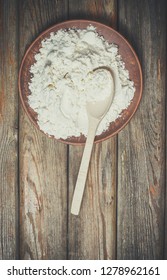 Wooden spoon in flour on the table in vintage style