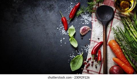Wooden spoon and ingredients on dark background. Vegetarian food, health or cooking concept.