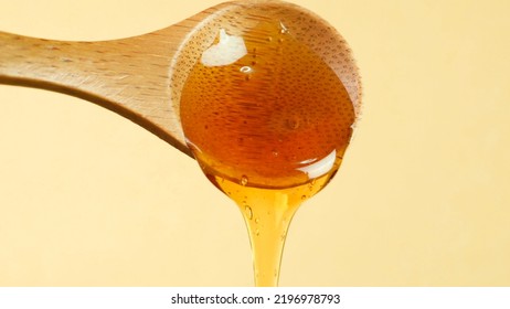 Wooden Spoon Pouring Honey. Close Up Shot. Health And Beauty Product Sustainable Lifestyle Concept. 