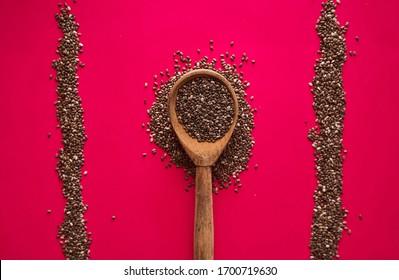 Wooden Spoon With Scattered Chia Seeds On A Red Background Closeup Banner