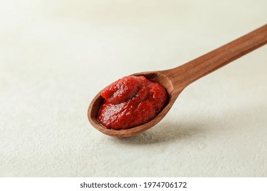 Wooden Spoon With Tomato Paste On White Textured Background