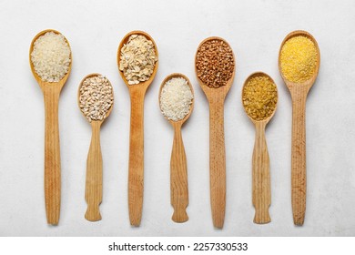 Wooden spoons of different cereals on light background - Shutterstock ID 2257330533
