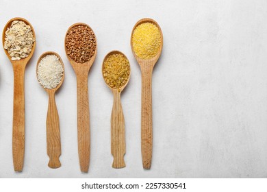 Wooden spoons of different cereals on light background - Shutterstock ID 2257330541