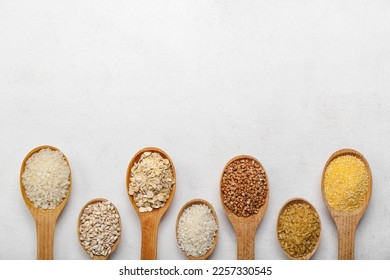 Wooden spoons of different cereals on light background - Shutterstock ID 2257330545