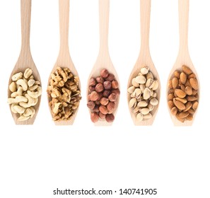 Wooden spoons full of different kinds of nuts: peanut, hazelnut, walnut, almond, pistachio, isolated over white background, top view