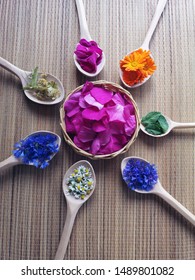 wooden spoons with medical herbs flowers on bamboo mat