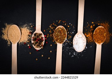 wooden spoons with seasonings on a black board - Shutterstock ID 2244821529