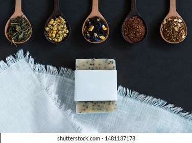Wooden Spoons With A Variety Of Loose Leaf Teas On A Dark Background White Towel And Handmade Soap, Bar Soap With Ingredients, Heaps Of Tea Leaves, Copyspace, Mockup, Graphic Design Copy Space