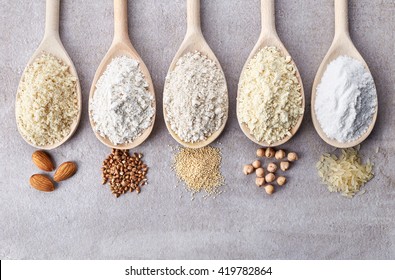 Wooden spoons of various gluten free flour (almond flour, amaranth seeds flour, buckwheat flour, rice flour, chick peas flour) from top view - Shutterstock ID 419782864